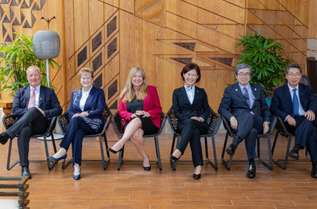 Six leaders from top five intellectual property offices sit side by side with their right leg crossed over their left