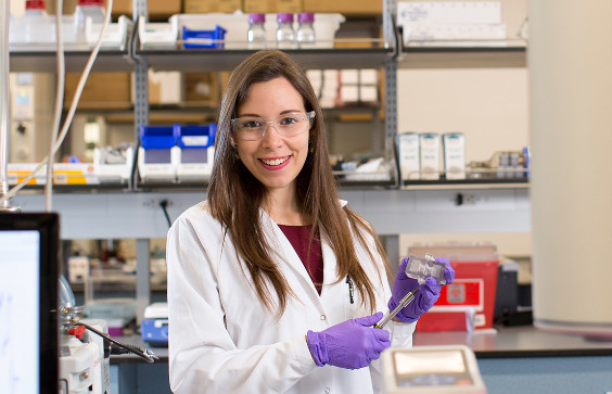 Headshot of Daniela Blancoin posing with a scientific instrument in the lab