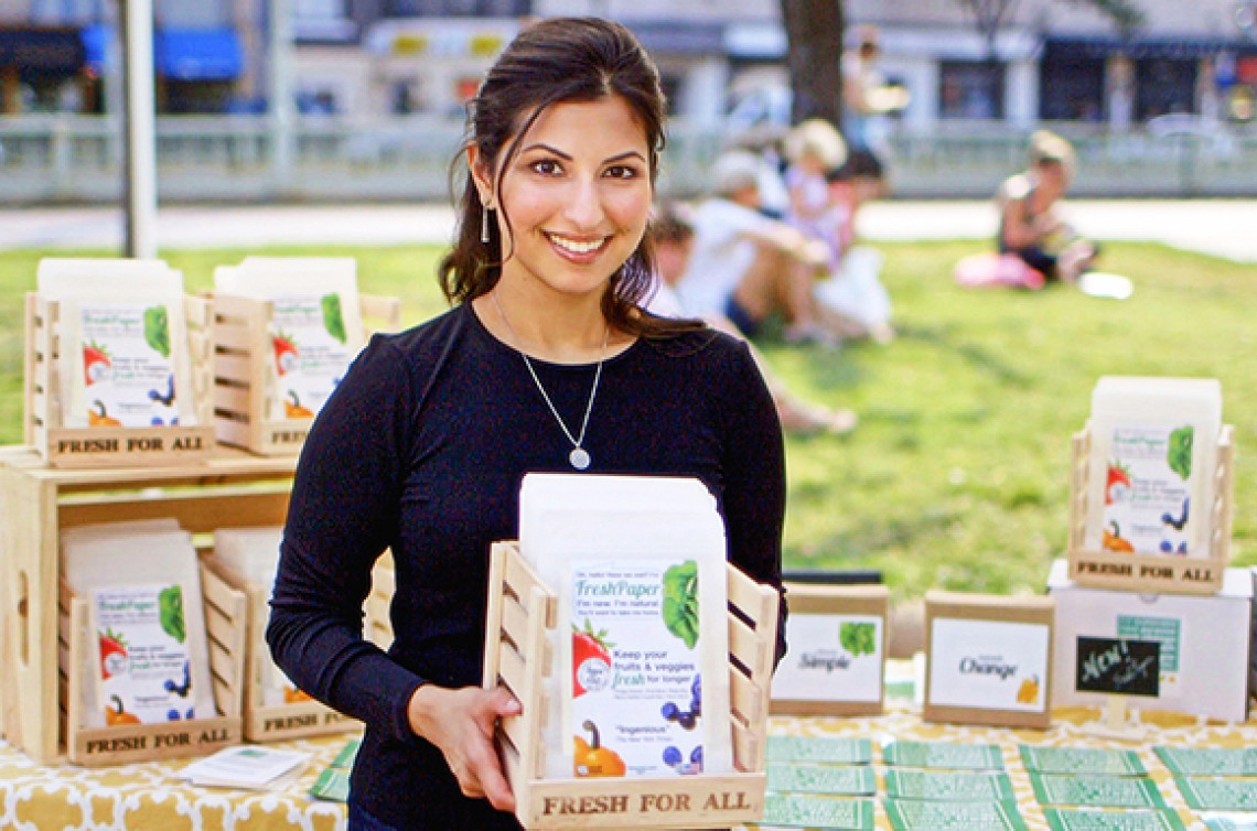 Kavita Shukla smiles while holding a basket of vegetable seed packs