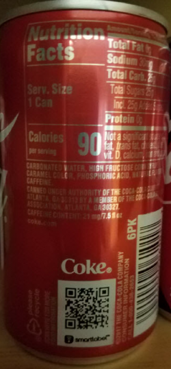 Coke specimen shows trademark use for soft drinks. The specimen is a photograph of a can of Coke. The trademark is shown above a QR code. 