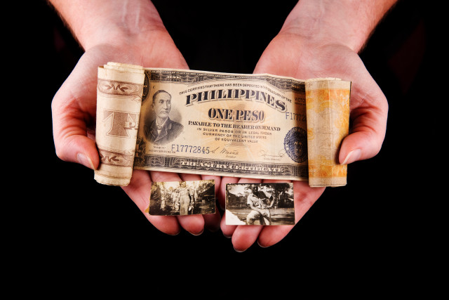 hands holding money roll, a collection of Allied Military Currency (AMC) from when holder's grandfather was stationed in the Philippines with the Army Air Corps, and photographs of grandfather during this time.
