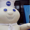 Photo of costume character Pillsbury Doughboy standing in front of the Expo booths.