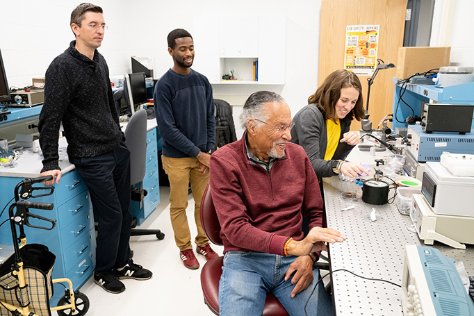 James West works with students in his lab at MIT