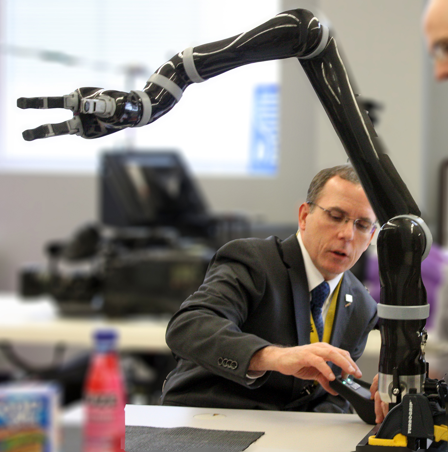 Cooper in lab in a suit working on a robotic arm