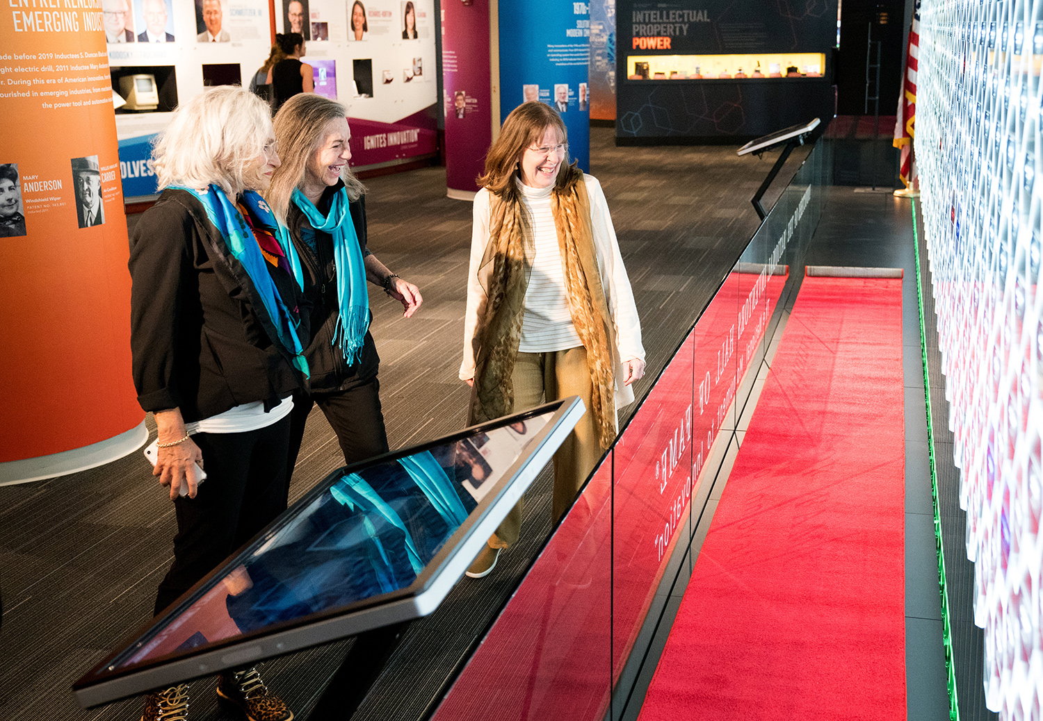 Hinda Miller, Lisa Lindahl, and Polly Smith laugh while viewing the Gallery of Icons in the N I H F Museum. 
