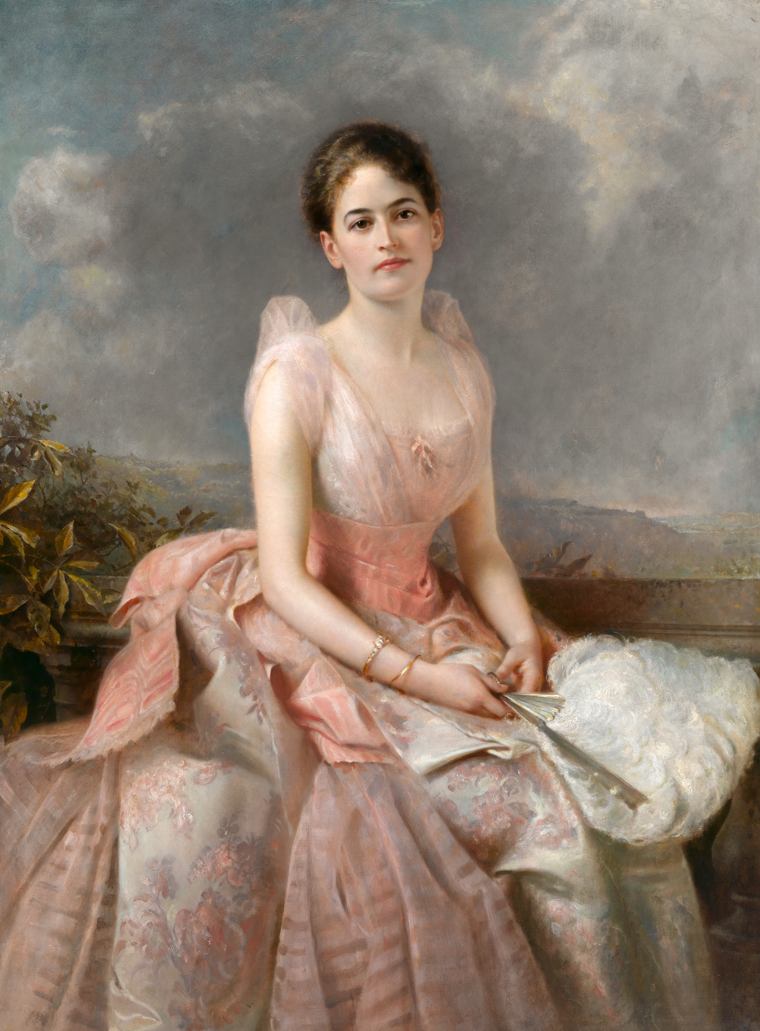 Juliette Gordon Low as a young woman, seated, wearing an elaborate, flowing silk dress and holding a feathered fan in her lap.