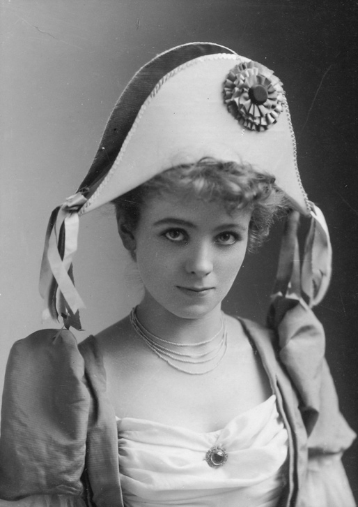 A young woman wearing Napoleonic hat and smirking 