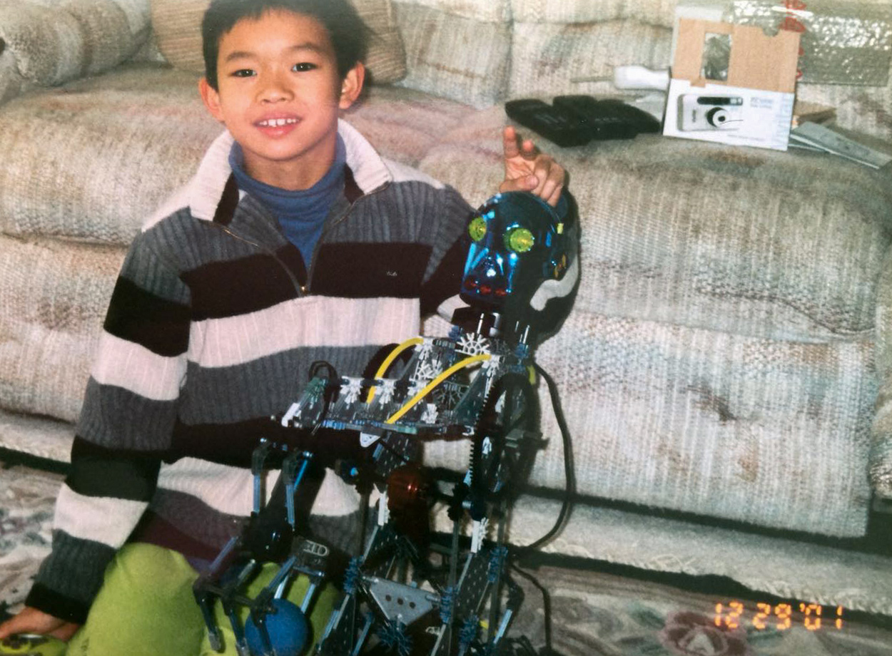 Kang as a child, showing off a robot he built.