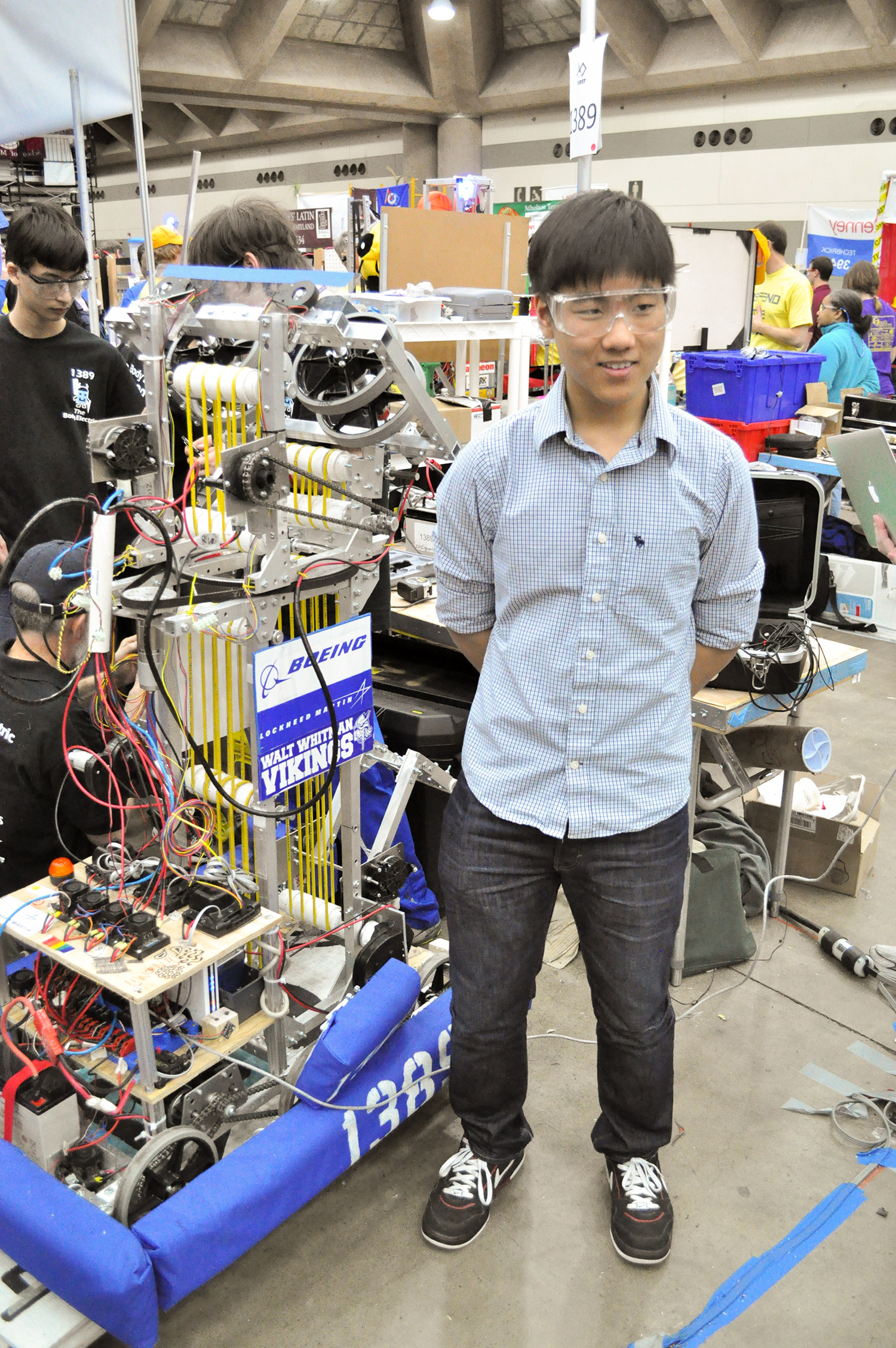 Tyan stands next to a robot he invented in high school.