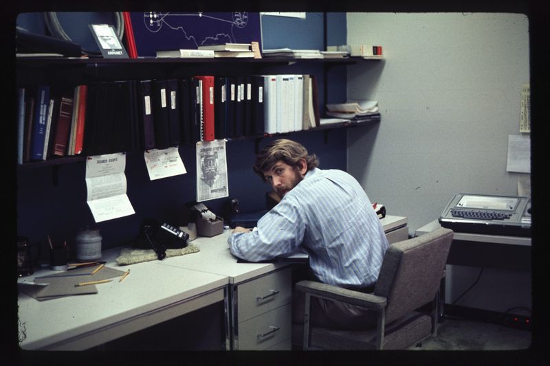 Bob Metcalfe seated at his desk circa 1973