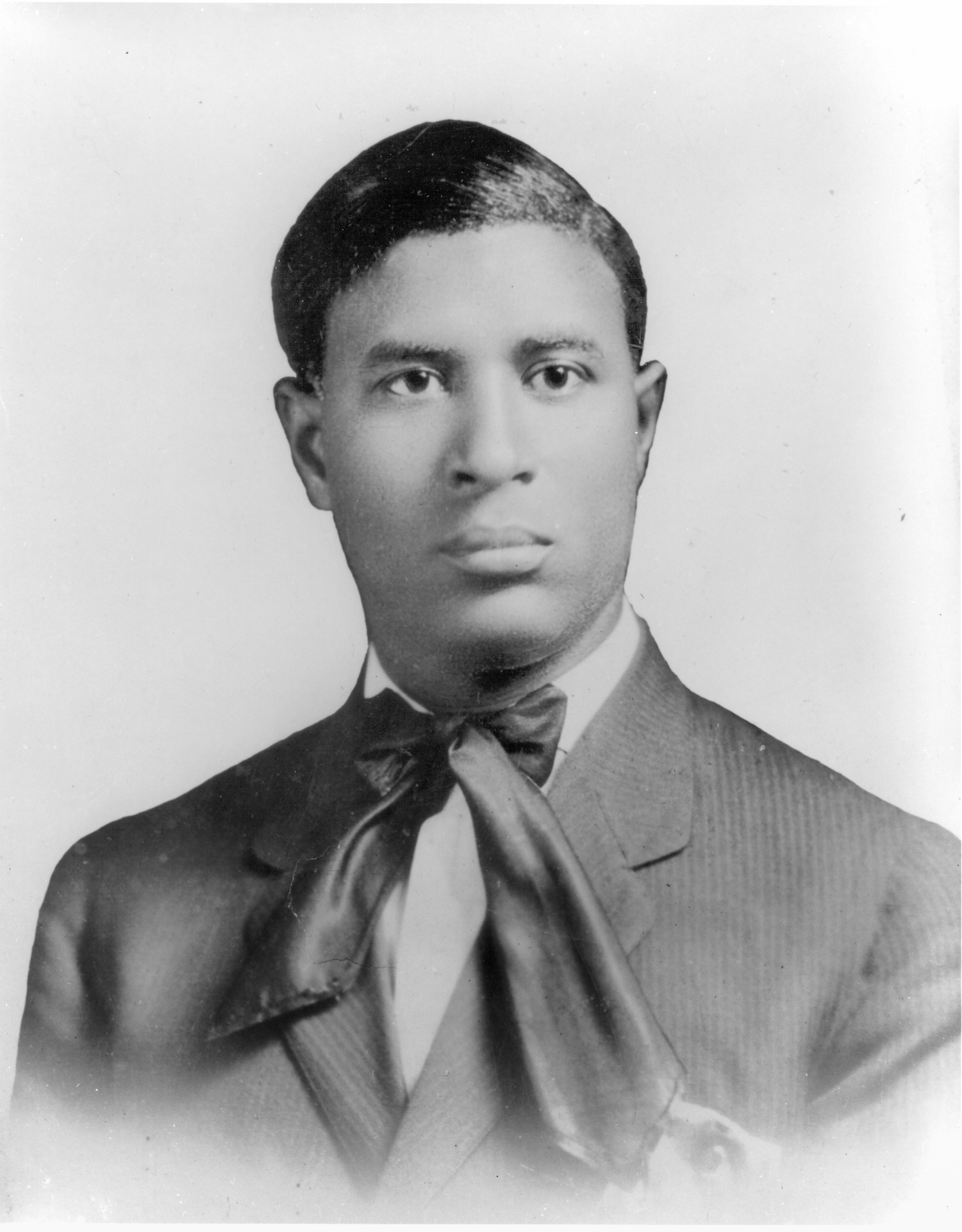 Portrait of a young Garrett Morgan wearing a suit and silk tie