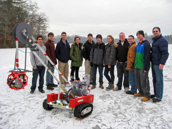 Doug Scott stands outside with his Natick High School InvenTeam students in 2013