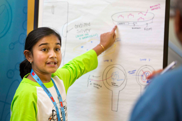 Gitanjali Rao pointing at a piece of paper with writing