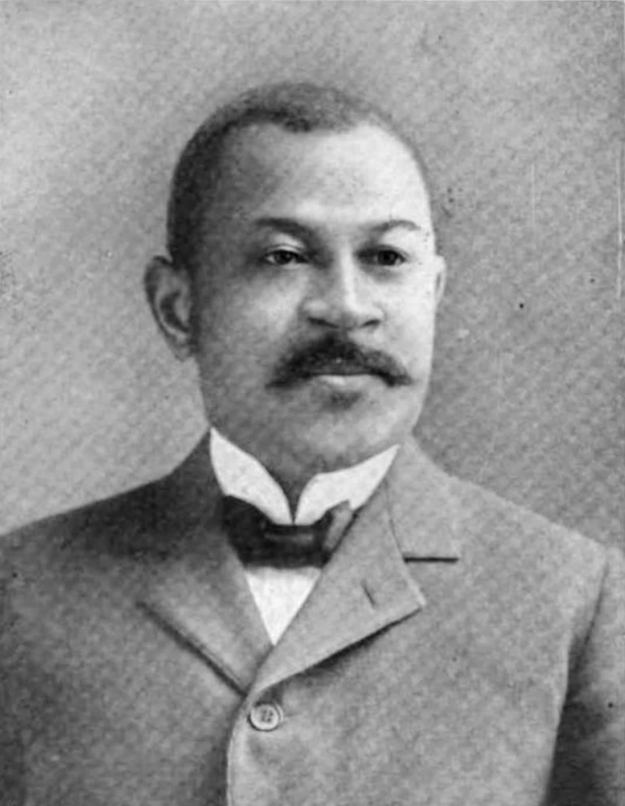 Black and white photo of Henry Baker, an African American man, wearing a suit and bowtie