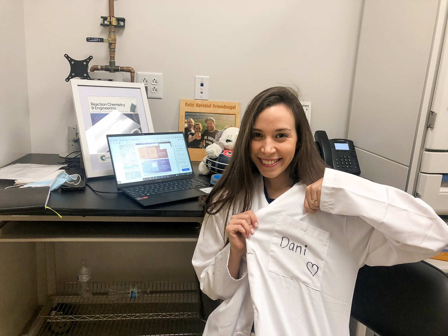 Daniela Blanco turns from a lab desk and computer and excitedly gestures to the chest of the white lab coat she wears. Where a name tag might usually be, the coat reads “Dani” handwritten in marker with a large heart hand drawn below.