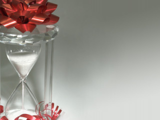 Clear hourglass filled with water with a gift bow on top