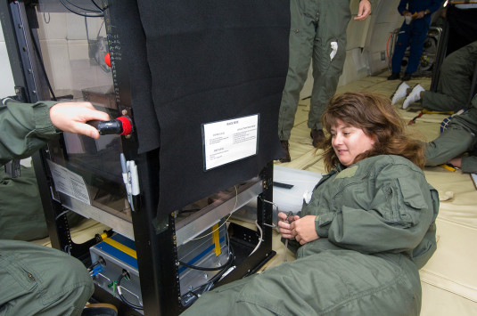  Jackie Quinn examines a piece of equipment on the ground with four team members working in the background