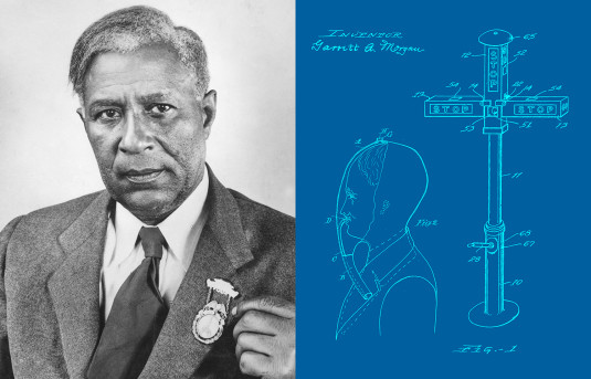 Garrett Morgan with a medal pinned to his suit jacket alongside drawings from his smoke hood and traffic signal patent