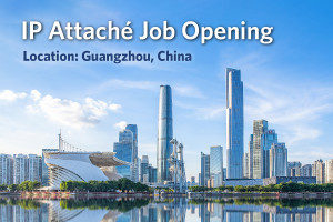 Photograph of downtown Guangzhou, China cityscape, showcasing the mirrored buildings reflecting onto the water. Text reads “IP Attaché Job Opening. Location: Guangzhou, China.”