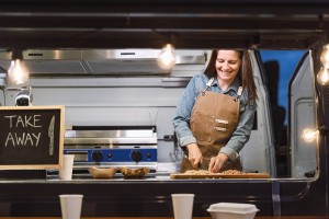Female food truck chef working behind the counter with a smile