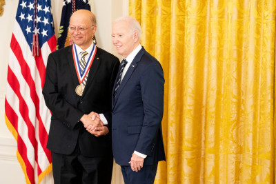 Ashok Gadgil wearing dark suit and glasses shakes President Biden’s hand while receiving the National Medal of Technology and Innovation. 