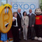 Photo of photographers snapping a photo of the Director and Commissioner for the Patent and Trademark office posing with the T.Markey and Curious George costume characters.