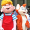 Photo of the costume characters Curious George, Dennis the Menace, FauxPaw the cat, and Hershey Kiss posing in a line.